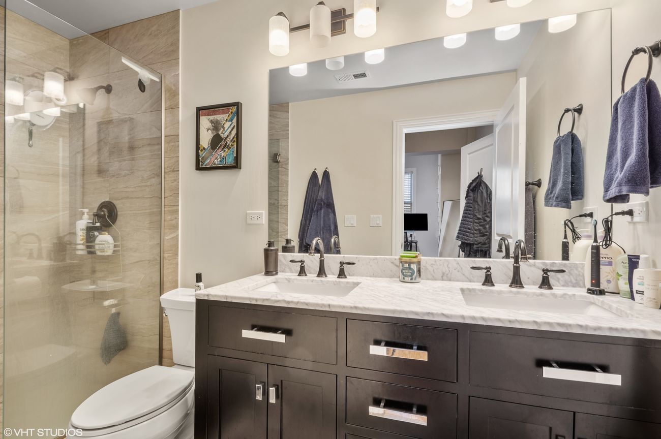 The Evergreen — bathroom with marble double vanity and glass shower