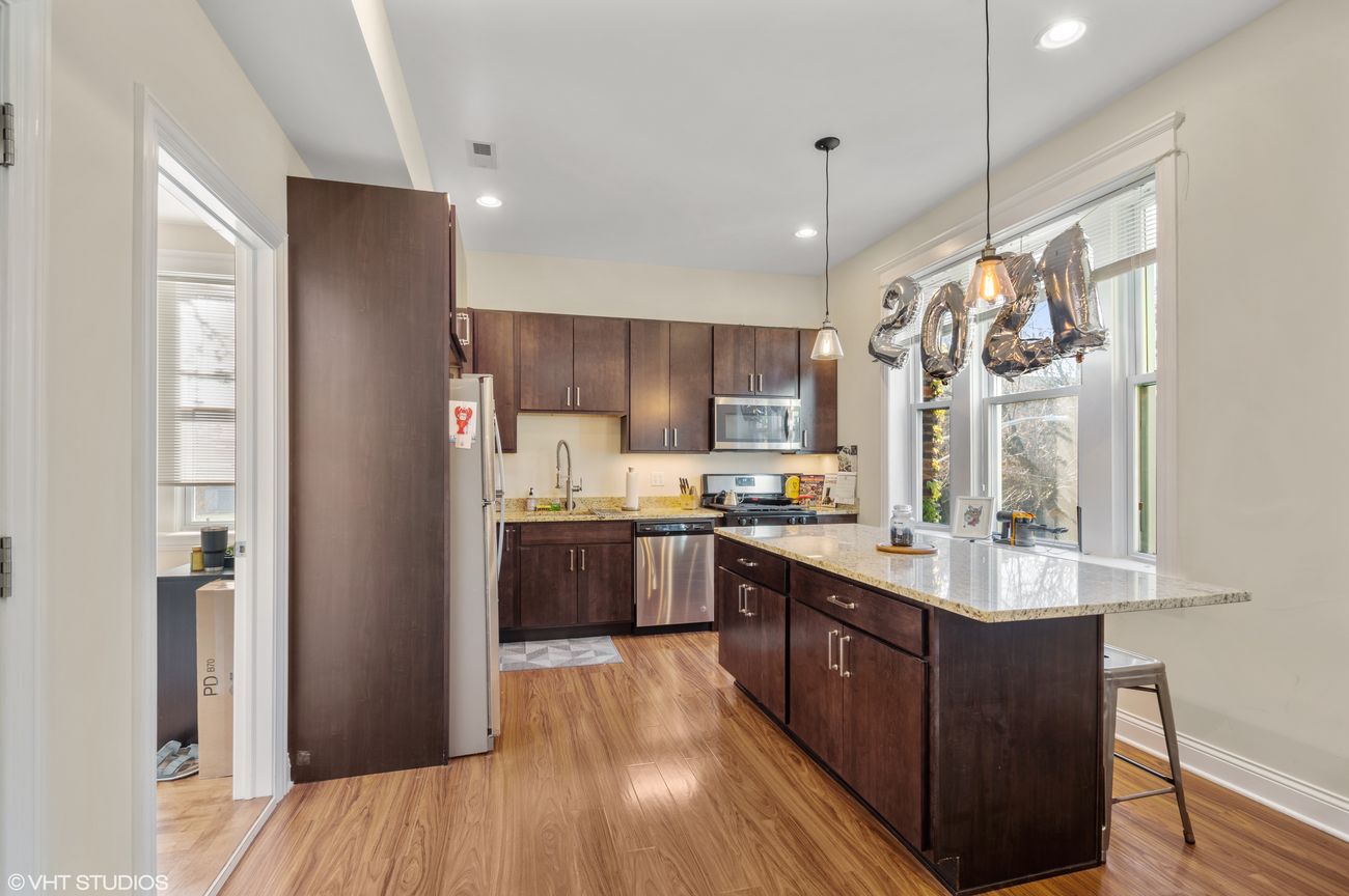 The Evergreen — kitchen in one of the building's units, granite counters and stainless appliances