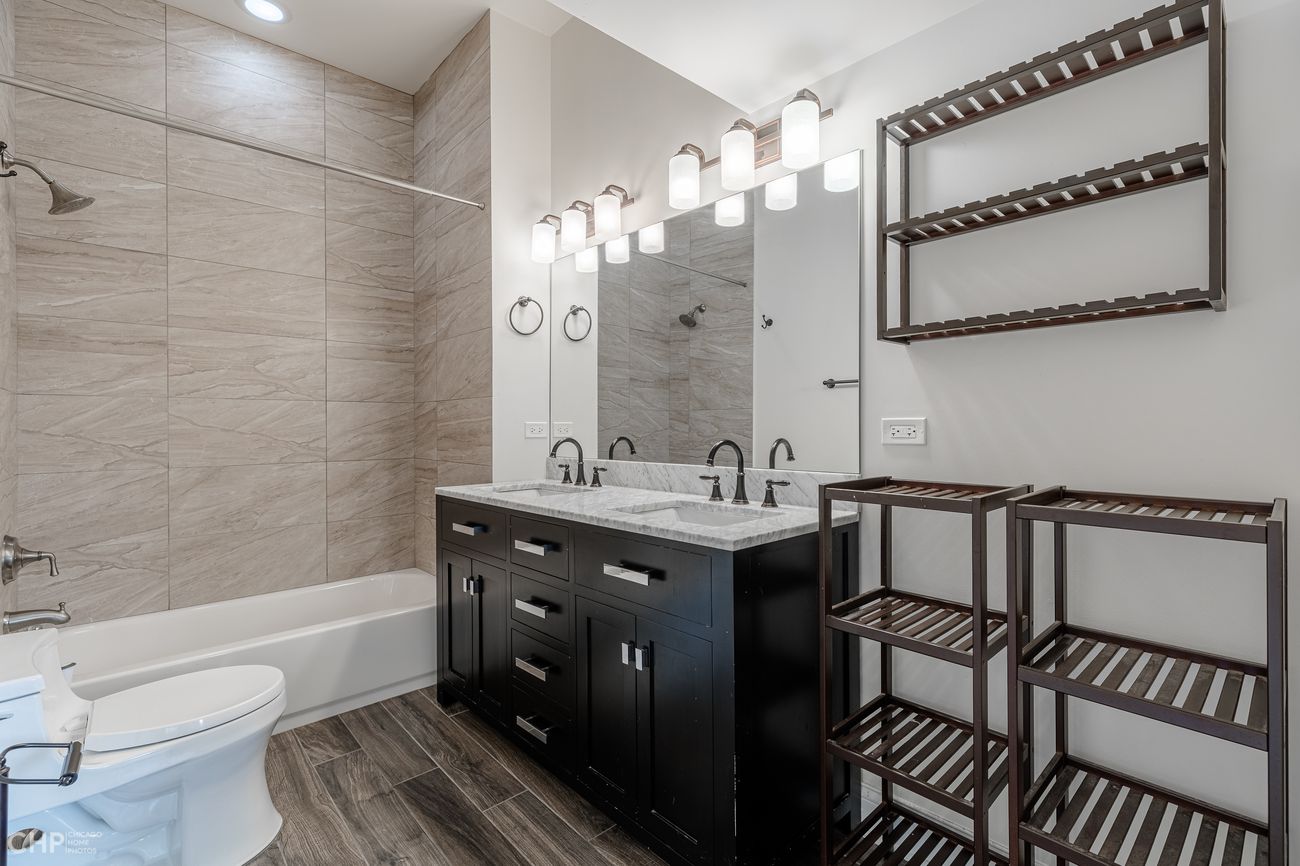 The Evergreen — bathroom in the second unit with marble double vanity and tub/shower