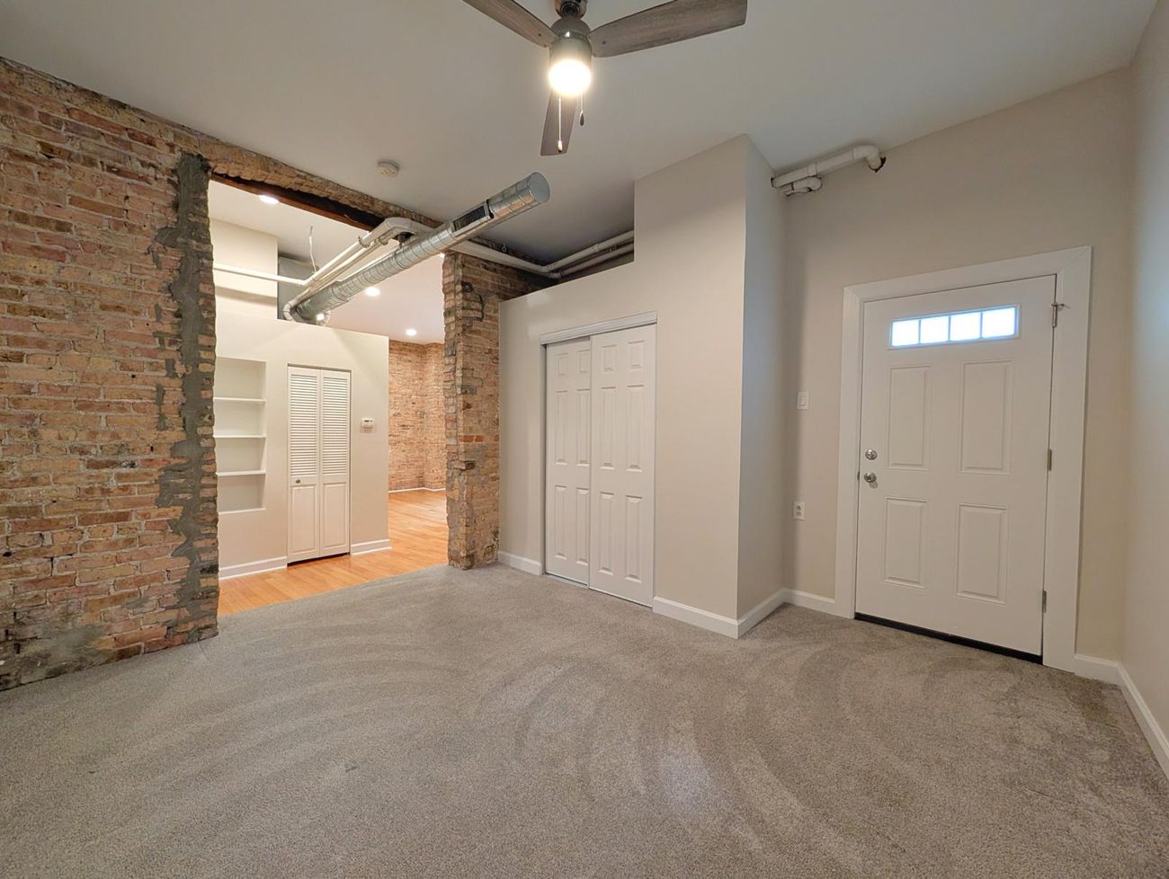 The Evergreen — entry of a third unit with exposed brick and private exterior door