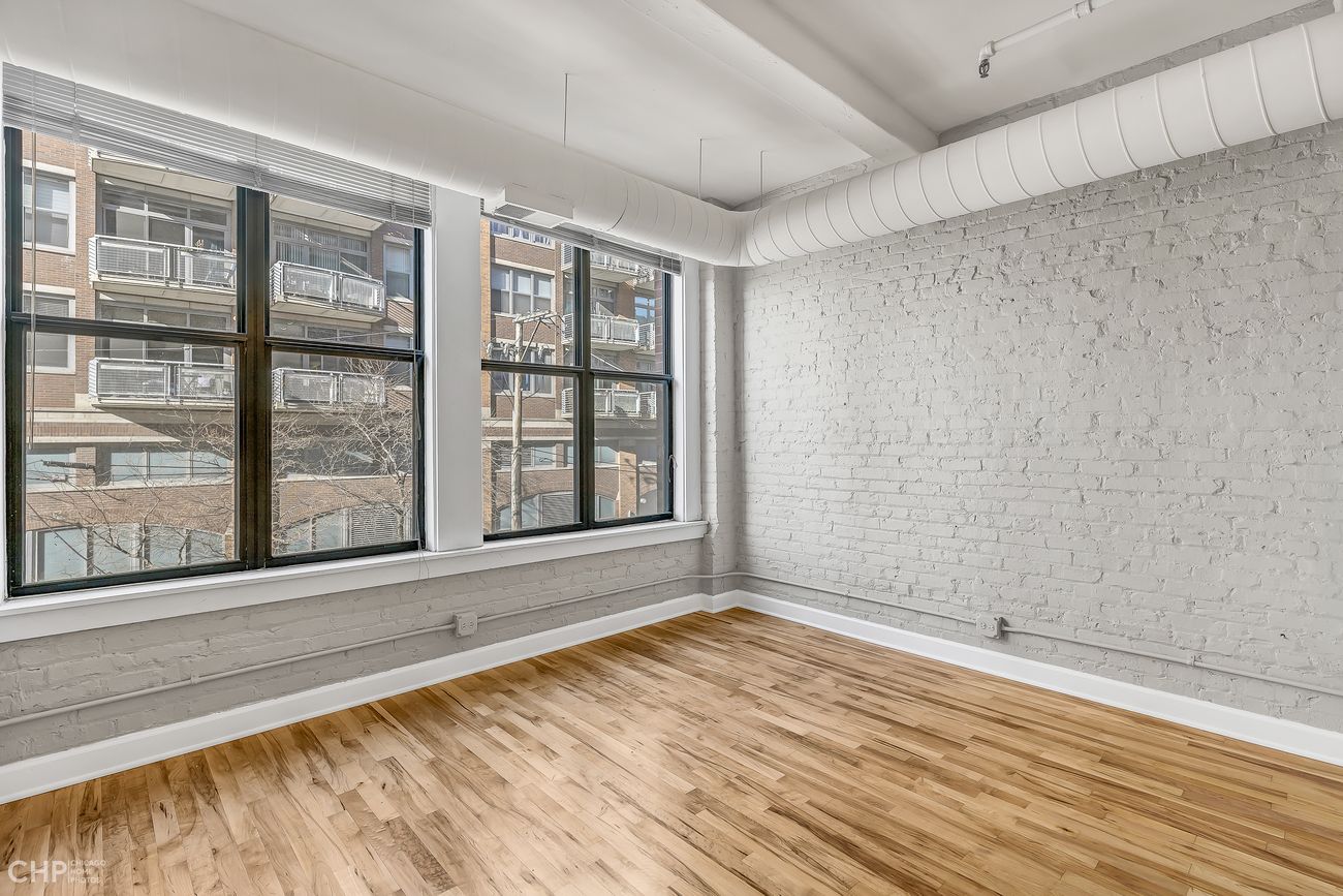 Sangamon Loft 1 — bedroom with large windows and exposed brick wall