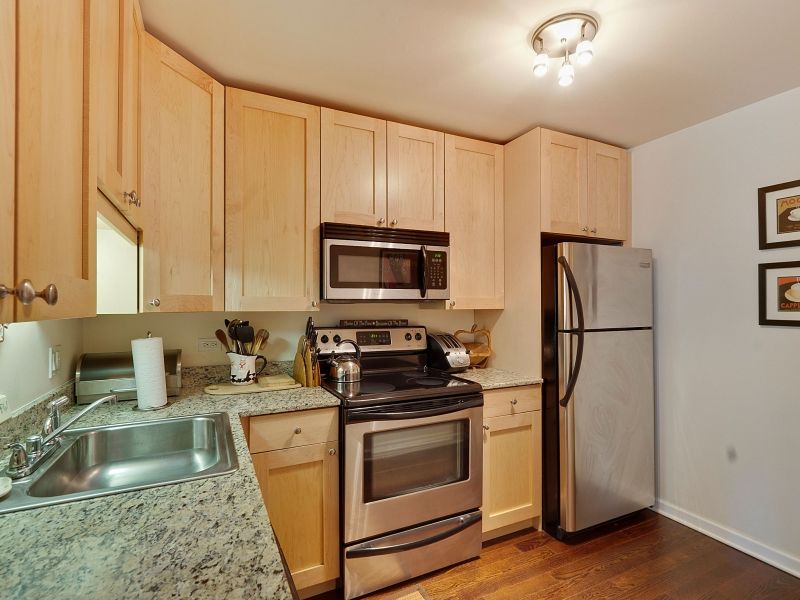 Sheridan Tower Condo — kitchen with maple cabinetry and granite counters